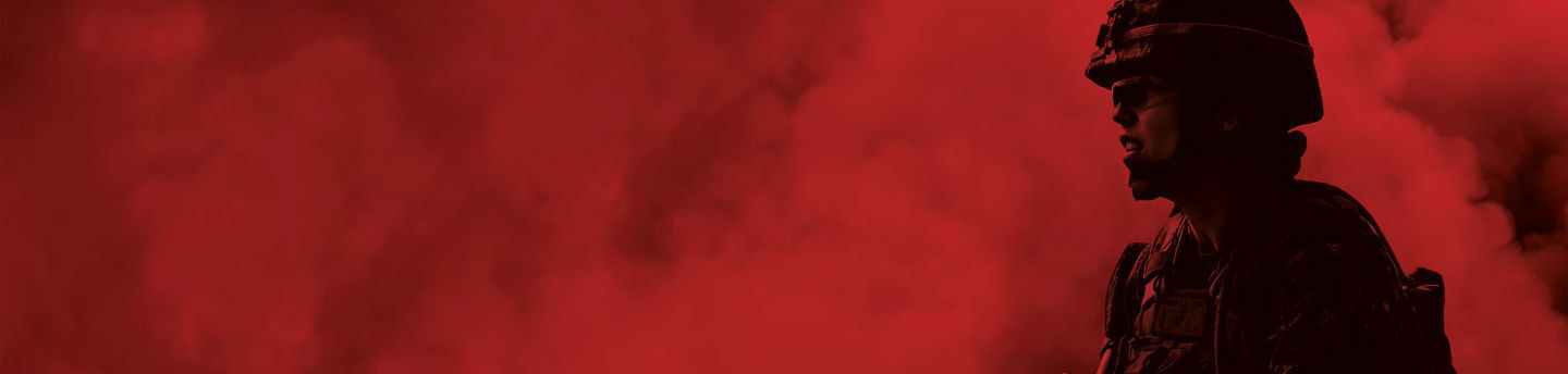 Silhouette of a Marine in profile, wearing a helmet, against a red, smoky background with a dark fade on the left.